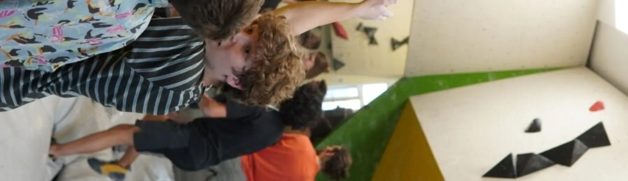 Jugendliche in einer Boulderhalle besprechen eine Kletterroute an der Wand. | © Marcel Dippon